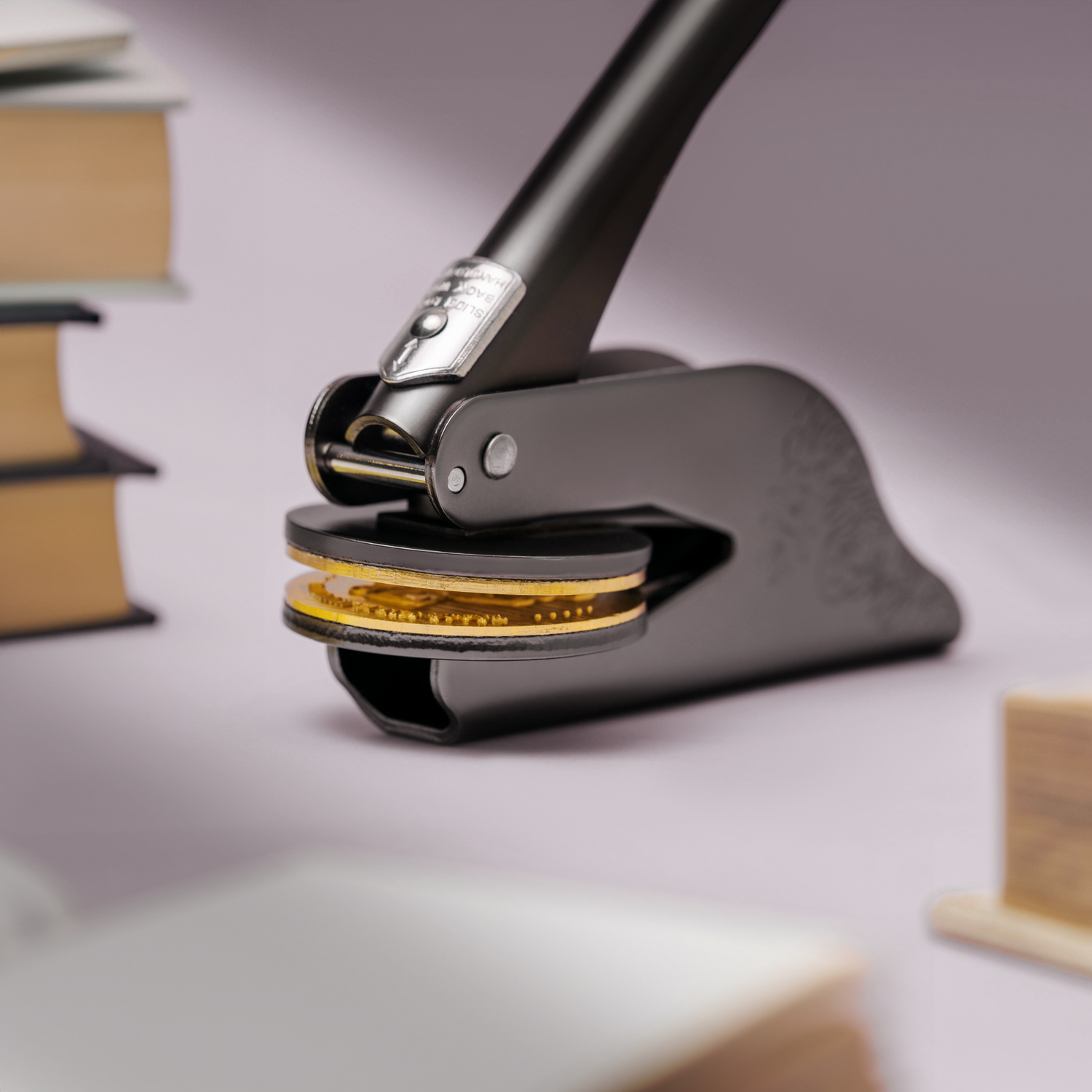 Personalisierter Buchstempel aus Stahl neben Büchern platziert – elegant und langlebig.