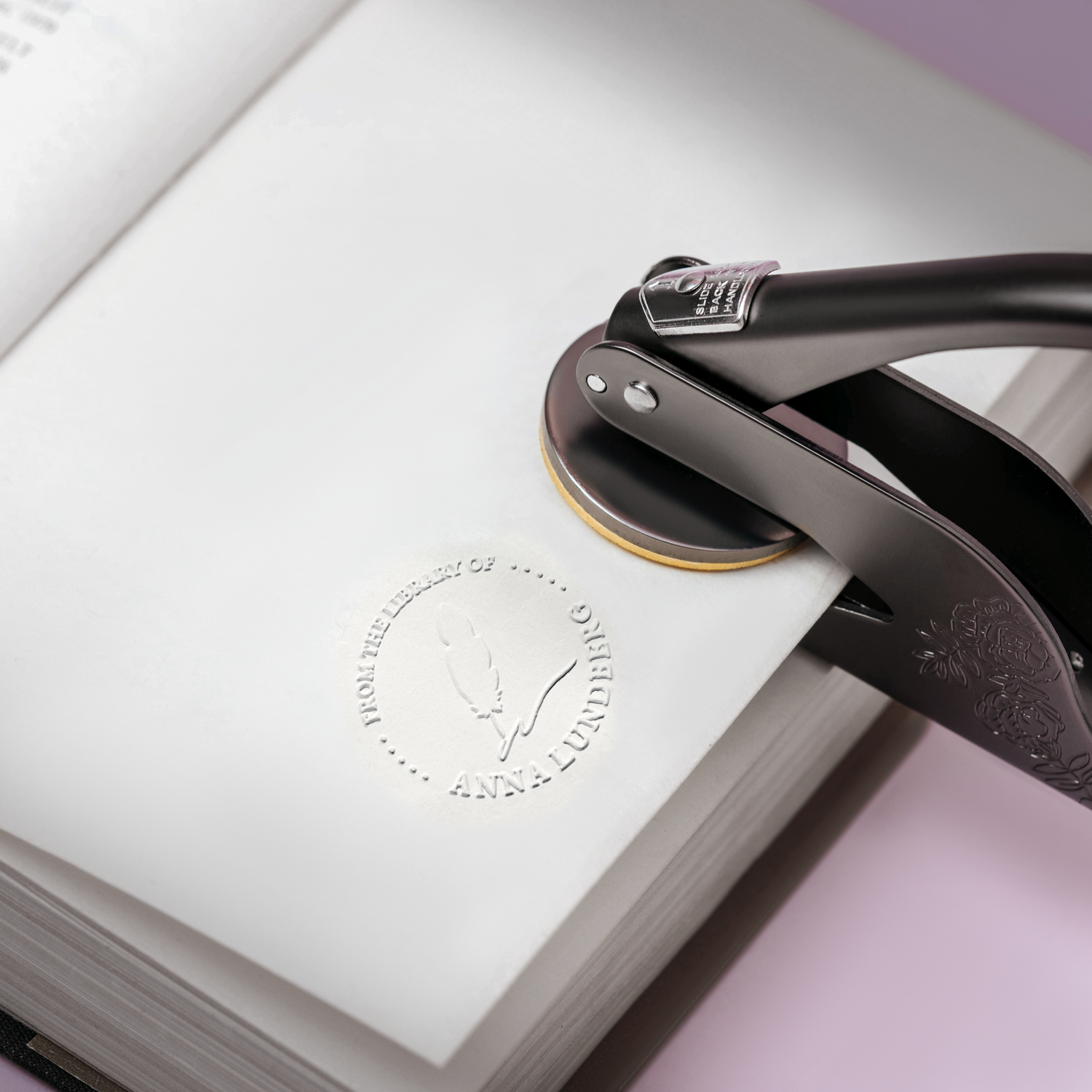 Ein personalisierter Buchstempel wird verwendet, um eine Buchseite mit Namen und Design zu prägen.
